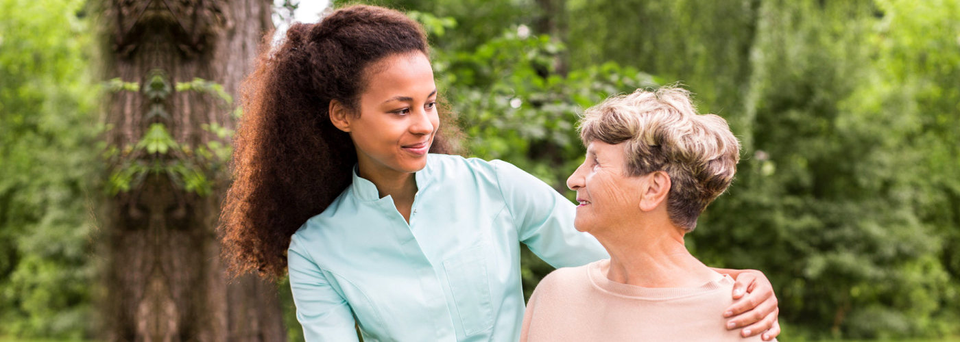 senior woman and female caregiver looking at each other